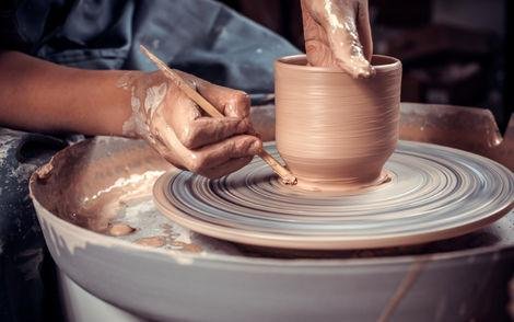 Hands working pottery on wheel